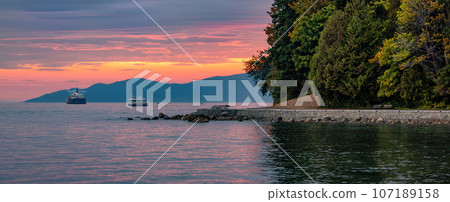 Seawall in Stanley Park during Dramatic Sunset on West Coast of Pacific Ocean. 107189158