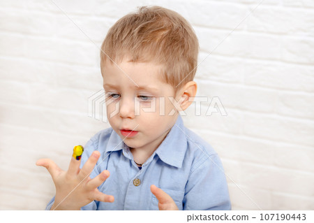 Funny child drawing with fingers in album using special paint. Funny child drawing with fingers in album using special paint. 107190443