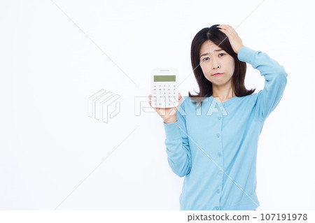 一名 30 多歲的女性拿著計算器，在白色背景前擔心 107191978