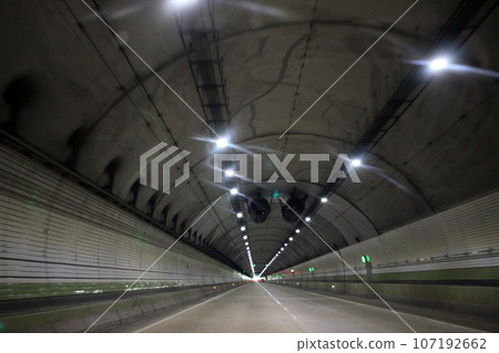 Defocused image of a road in the tunnel, bokeh lights. Trail for cars. Defocused image of a road in the tunnel, bokeh lights. Trail for cars. 107192662