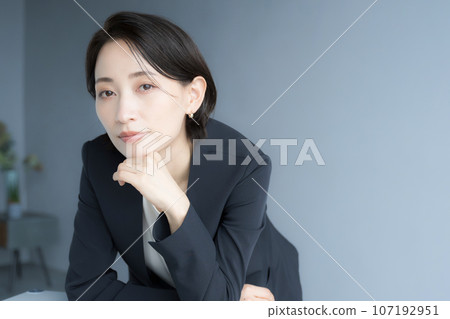 一個很酷的職業女性手放在下巴上，表情嚴肅地看著鏡頭的形象 107192951