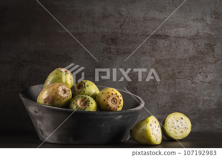 Modern design black ceramic bowl with green indian figs Modern design black ceramic bowl with green indian figs 107192983