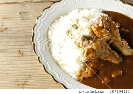 An overhead shot of curry rice with bone-in chicken An overhead shot of curry rice with bone-in chicken 107194111