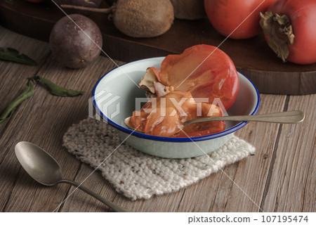 Persimmon fruit on rustic table Persimmon fruit on rustic table 107195474