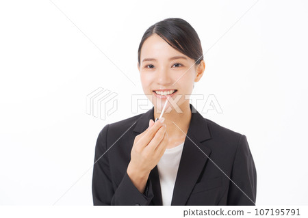 Suit woman applying lipstick 107195791