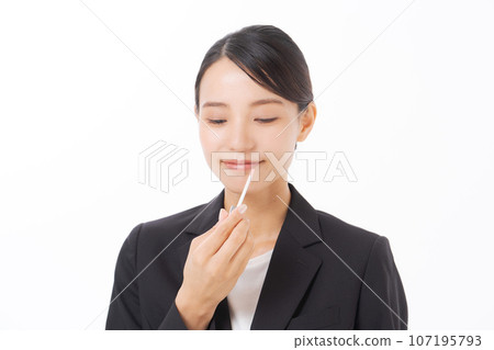 Suit woman applying lipstick 107195793