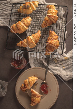 Baked croissants with strawberry jam 107196161