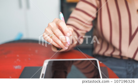 Woman taking work notes on tablet Suitable for making infographics. 107196326