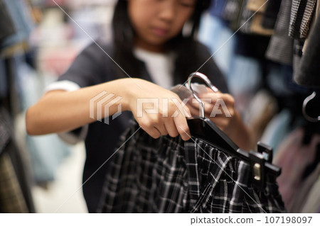 A child choosing clothes at a department store 107198097