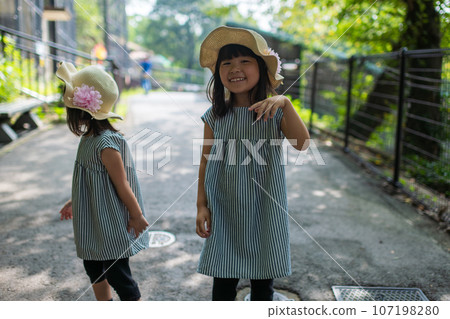 Sisters enjoying their first zoo visit Sisters enjoying their first zoo visit 107198280