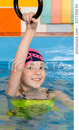 Child in swimming pool excersizing with sport rings Child in swimming pool excersizing with sport rings 107199234