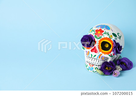 Mexican skull and flowers on blue background, space for text 107200015