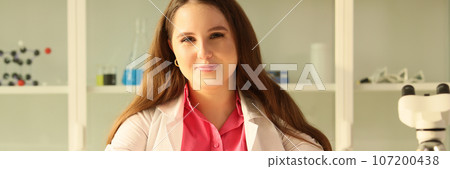 Young female scientist in research laboratory smiling and looking at camera. Young female scientist in research laboratory smiling and looking at camera. 107200438