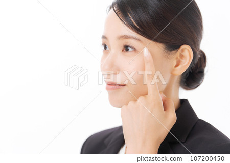 Photo of a woman in a suit pointing at her eyes 107200450