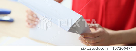 Close-up of office manager holding stack of blank paper while sitting at desk. Close-up of office manager holding stack of blank paper while sitting at desk. 107200474