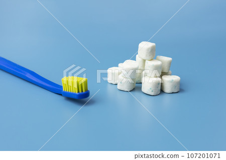 Bunch Of Healthy Sugar-Free Xylitol Cubes Of White Chewing Gum, Toothbrush on Blue Background. Healthy Teeth, Beautiful Smile Concept. Top View, Copy Space. Heap of Bubble Gum. Horizontal Plane. 107201071