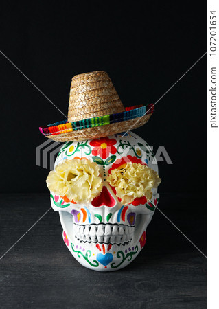 Mexican skull in sombrero and flowers on black background Mexican skull in sombrero and flowers on black background 107201654