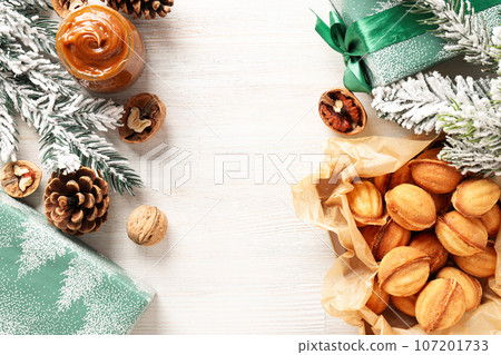 Nuts cookies on the table with a Christmas tree branch Nuts cookies on the table with a Christmas tree branch 107201733