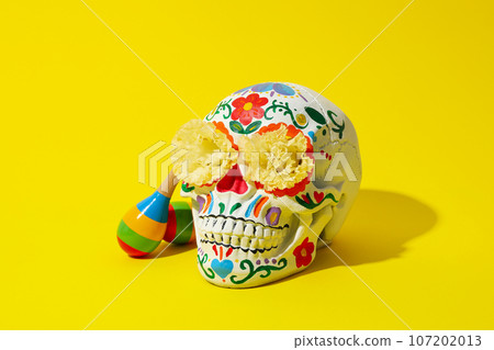 Mexican skull, flowers and maracas on yellow background 107202013