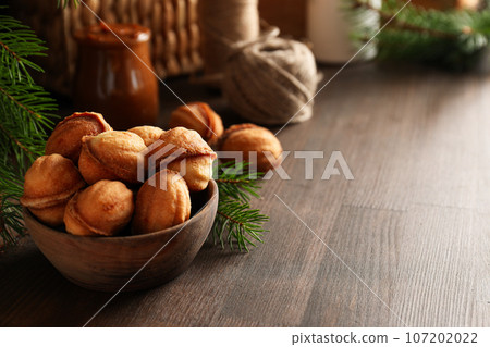 Cookies Nuts in a bowl with a sprig of needles Cookies Nuts in a bowl with a sprig of needles 107202022