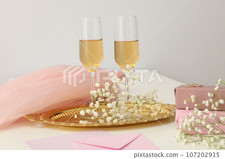 Gift boxes, flowers and glasses with wine on light background Gift boxes, flowers and glasses with wine on light background 107202915
