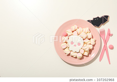 Pink bowl of skull cookies with marshmallows 107202968