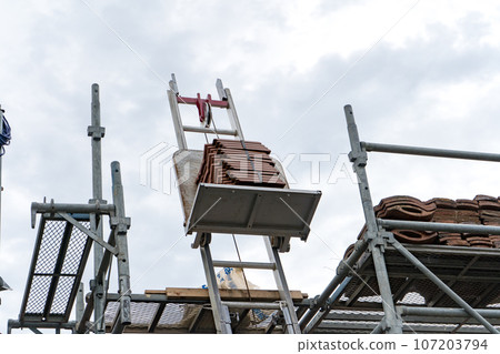 Scaffolding installed to replace roof tiles of an old detached house | Roof renovation image | Tile renovation image Scaffolding installed to replace roof tiles of an old detached house | Roof renovation image | Tile renovation image 107203794