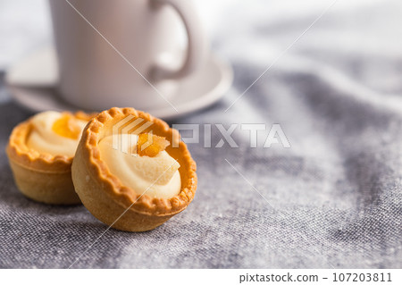 Sweet tarlets. Tasty mini tarts. Mini pie with cream on kitchen table. 107203811