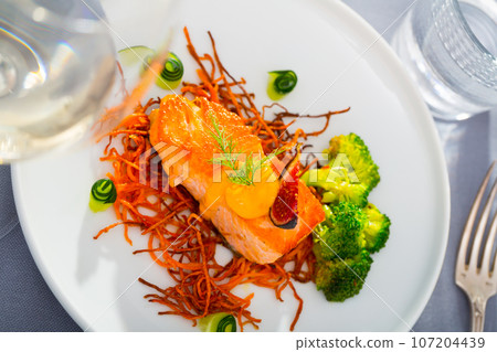 Fried salmon with smoked julienne carrot, broccoli, cucumber, figs 107204439