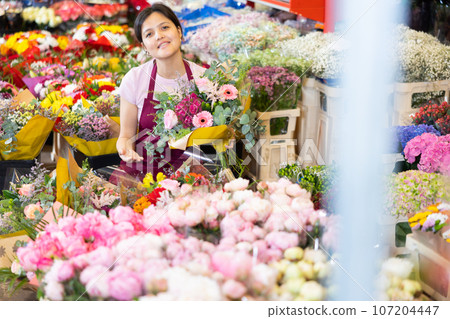Portrait of female flower market seller with bouquets of flowers 107204447