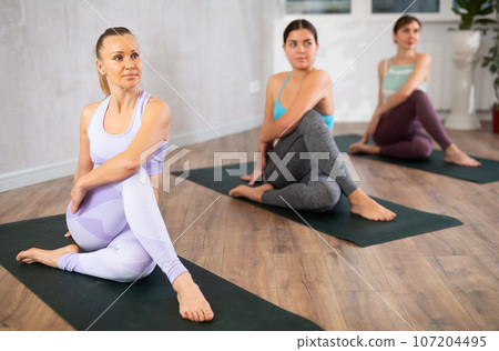 Three women doing yoga in fitness studio Three women doing yoga in fitness studio 107204495