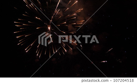 Gorgeous fireworks sparkling pattens in dark evening sky. Fireworks dazzling display amuses holiday party visitors at night. Abstract flash flame patterns fill sky at festive fireworks show Gorgeous fireworks sparkling pattens in dark evening sky. Fireworks dazzling display amuses holiday party visitors at night. Abstract flash flame patterns fill sky at festive fireworks show 107204518