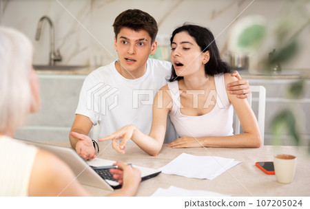 Insurance agent explaining conditions of insurance in home 107205024