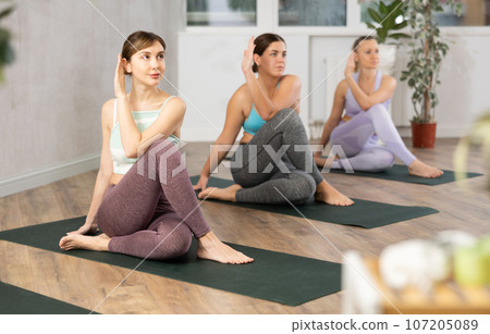Three women doing yoga in fitness studio Three women doing yoga in fitness studio 107205089
