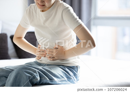 Asian teenager girl suffering from abdominal pain,gastritis,peptic ulcer disease,young woman with stomach ache,symptom of gastrointestinal disorders,stomach ulcer,gastric problem,health care,medical 107206024