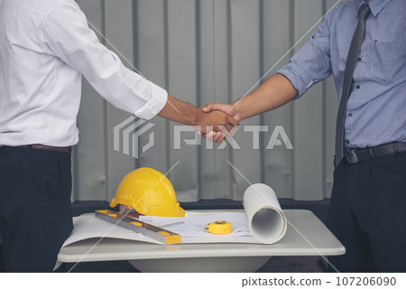 Close up warehouse worker shakehand together. Engineer man hands partnership. Diversity Coworker Men logistics Warehouse teams handshake. Multiracial Support team greeting person teamwork colleagues 107206090