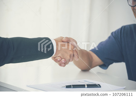 Team Business Partners shaking hands together to Greeting Start up new project. Shakehand Teamwork Partnership outside office modern city background. Businessman handshake together.  Business concept 107206111