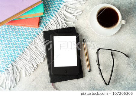 E-book reader, cup of coffee and glasses on gray surface 107206306