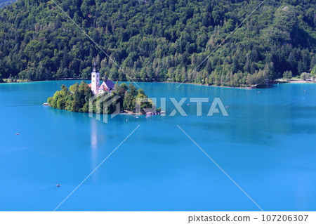 Lake Bled in Slovenia - Bled Island and Church of the Assumption floating in the turquoise lake seen from Bled Castle 107206307