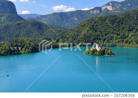 Lake Bled in Slovenia - Bled Island and Church of the Assumption floating in the turquoise lake seen from Bled Castle 107206308