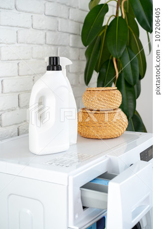 Detergent bottle on washing machine in a laundry room Detergent bottle on washing machine in a laundry room 107206405