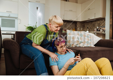 Elderly mother receives a crash course in online commerce from her daughter Elderly mother receives a crash course in online commerce from her daughter 107206621