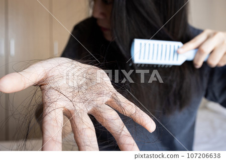 Stressed worried asian woman holding hair loss on hand during brushing her hair with comb,female patient with alopecia,hair fall disease,concept of beauty,health care and medical Stressed worried asian woman holding hair loss on hand during brushing her hair with comb,female patient with alopecia,hair fall disease,concept of beauty,health care and medical 107206638