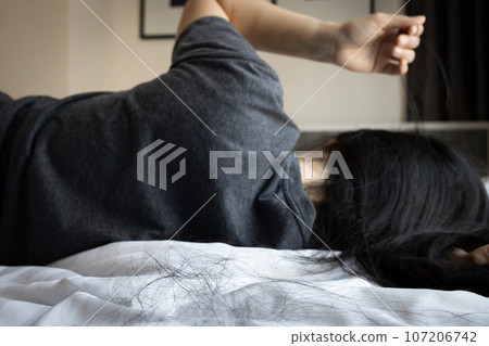 Asian woman pulling her hair with her fingers,mental health problems,brain system,female patient with trichotillomania disease,hair-pulling disorder,hair loss,health care and medical concept 107206742