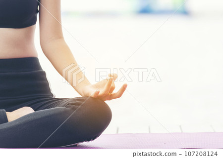 Women doing yoga hand in lotus position. Yoga fitness lifestyle healthy woman relaxation doing meditation. Yoga woman workout in sportswear sit on yoga mat home fitness workout exercise. Home fitness 107208124