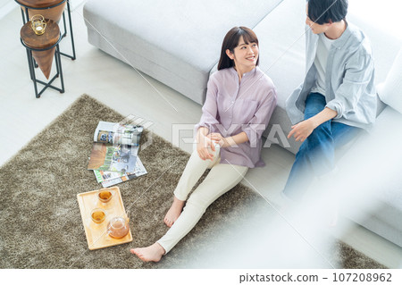 A young couple relaxing in the living room 107208962