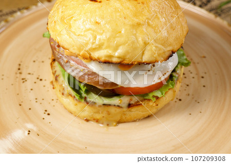 Juicy burger with beef tongue close-up. Selective focus Juicy burger with beef tongue close-up. Selective focus 107209308
