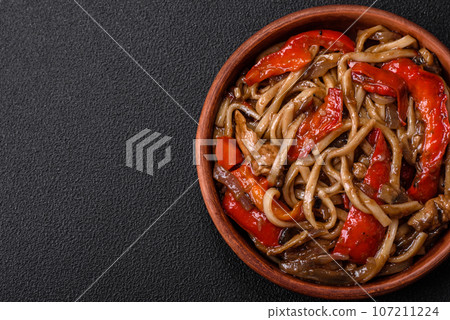 Delicious asian udon dish with vegetables, mushrooms, salt and spices Delicious asian udon dish with vegetables, mushrooms, salt and spices 107211224