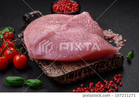 Raw turkey meat in the form of slices with salt, spices and herbs 107211271