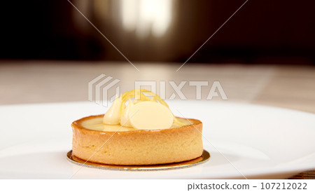 French patisserie. Still life with a delicious tartlet with lemon on a white plate 107212022